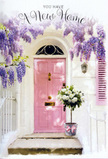 Approaching this sunlit doorway, you can almost picture yourself turning off a leafy road in Mill Hill and pausing at the threshold of a freshly painted home. A pale pink front door, softly luminous in the afternoon light, anchors the composition, its gentle blush tone inviting and calm. Above, cascades of wisteria in lavender and lilac tumble in loose clusters, their blossoms creating a dreamy canopy that frames the entrance with a sense of festivity. The surrounding walls are whitewashed, their slightly uneven texture catching and scattering the light so that subtle shadows and highlights play across the surface like moving clouds. Resting neatly at the base of the door is a vintage-style metal bucket in a cool grey shade, brimming with generously sized white and cream roses. The blooms are full and velvety, nestled among stems of dusty-green foliage that soften the arrangement and give it an effortlessly natural look, as though gathered from a local Mill Hill garden. A soft pink ribbon is tied around the bucket, its tails trailing lightly and echoing the colour of the door and the romantic hues above. The scene feels both sheltered and open, like a gentle pause before stepping into a new life chapter. It suggests a heartfelt housewarming gesture-perhaps delivered the same day to a new address off Daws Lane or near Mill Hill East-capturing the mixture of anticipation, comfort, and quiet joy that flowers can bring when a house is just beginning to become a home.